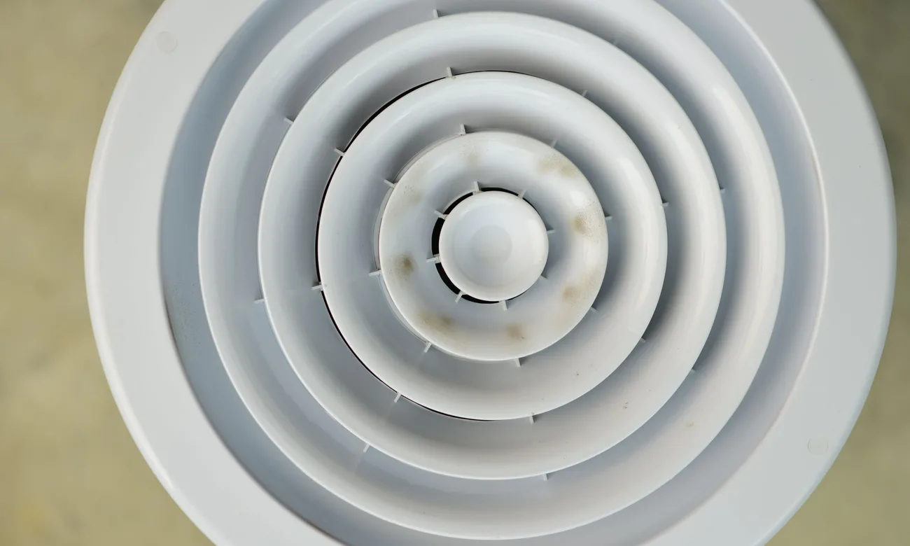 A floor supply vent in a Northwest Indiana home where duct leaks cause uneven comfort.