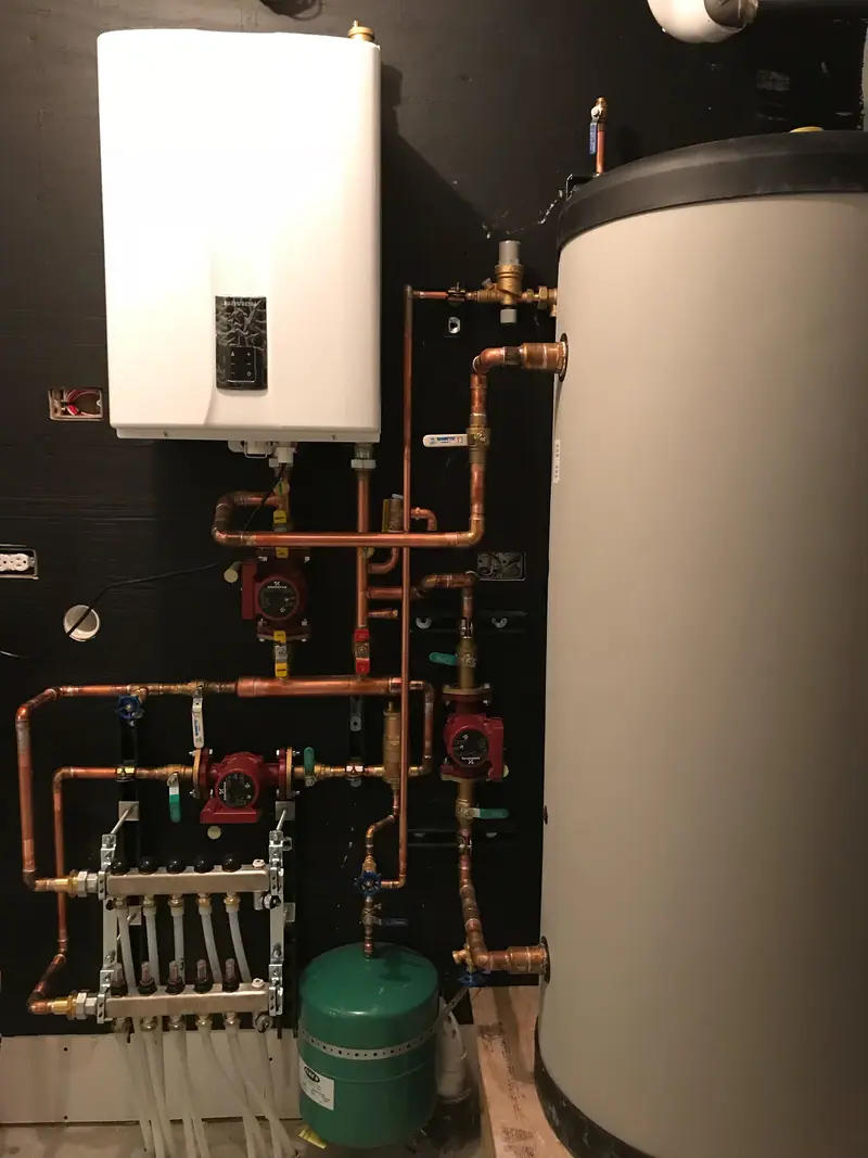 Compact wall-hung condensing boiler with copper near-boiler piping, circulators, and an indirect storage tank.