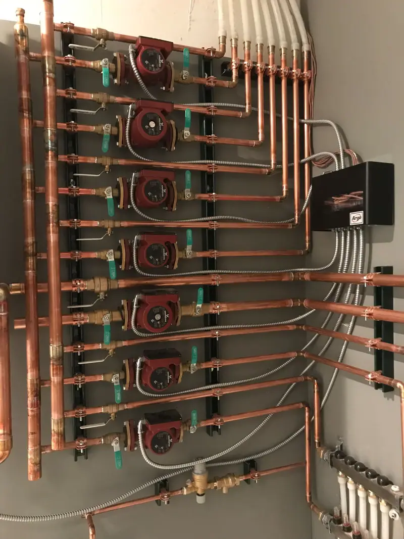 Seven-zone circulator pump array on copper piping for a hydronic radiant heating system.