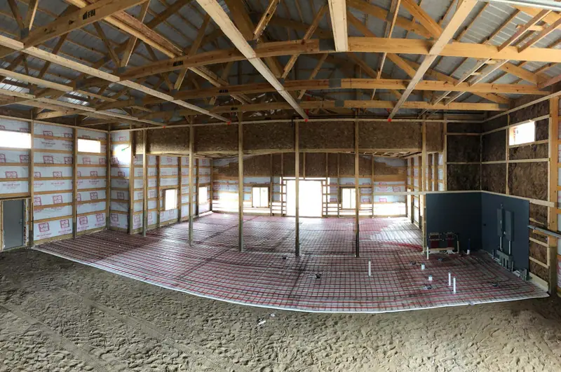 Panorama of radiant floor mesh and tubing across a framed home’s main level.