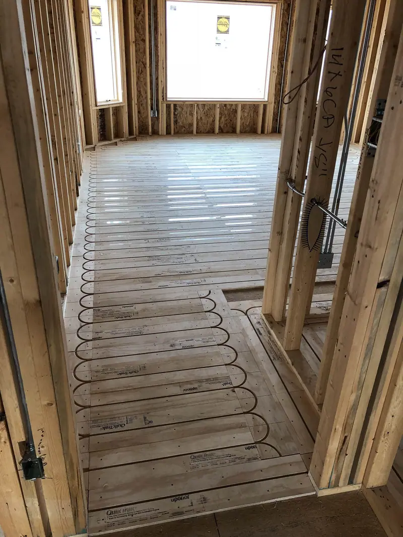 Radiant heat tubing snapped into grooved QuikTrak subfloor panels in a framed home.