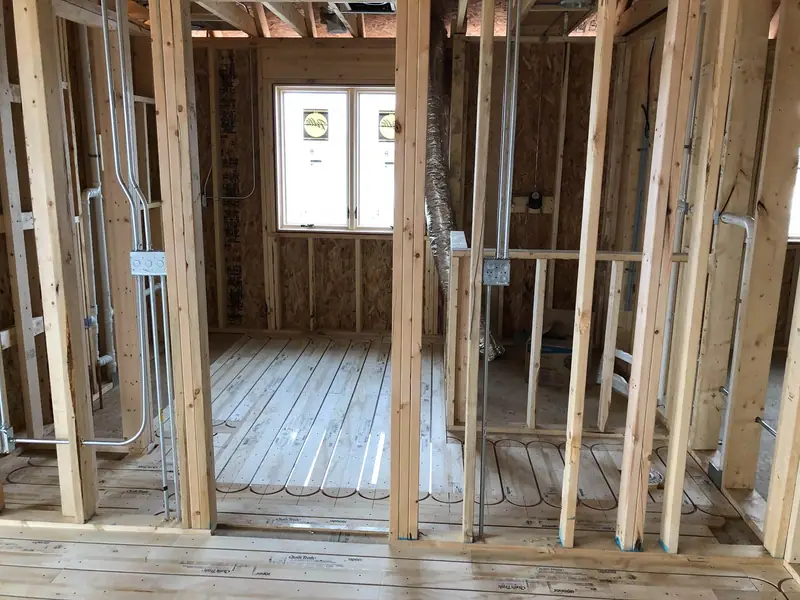 Radiant floor panels with PEX tubing running through a home’s framed rooms.